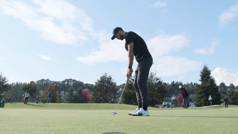 A golfer hits the ball with a club